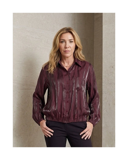 Soepelvallende blouse met knopen, borstzakje en subtiele glans, verkrijgbaar bij Marijke Mode.